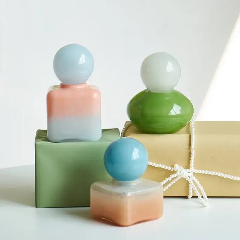 Pastel gradient geometric sphere glass perfume bottles with spherical caps used as desktop storage containers