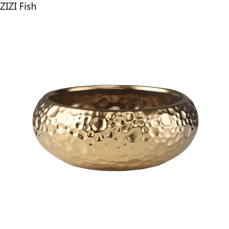 Gold-colored hammered metal bowl with textured bubble surface complementing minimalist ceramic vase decorbites decor