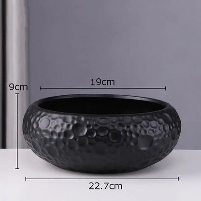 Black ceramic vase with textured hammered surface and raised circular patterns for minimalist ceramic vase decorbites style