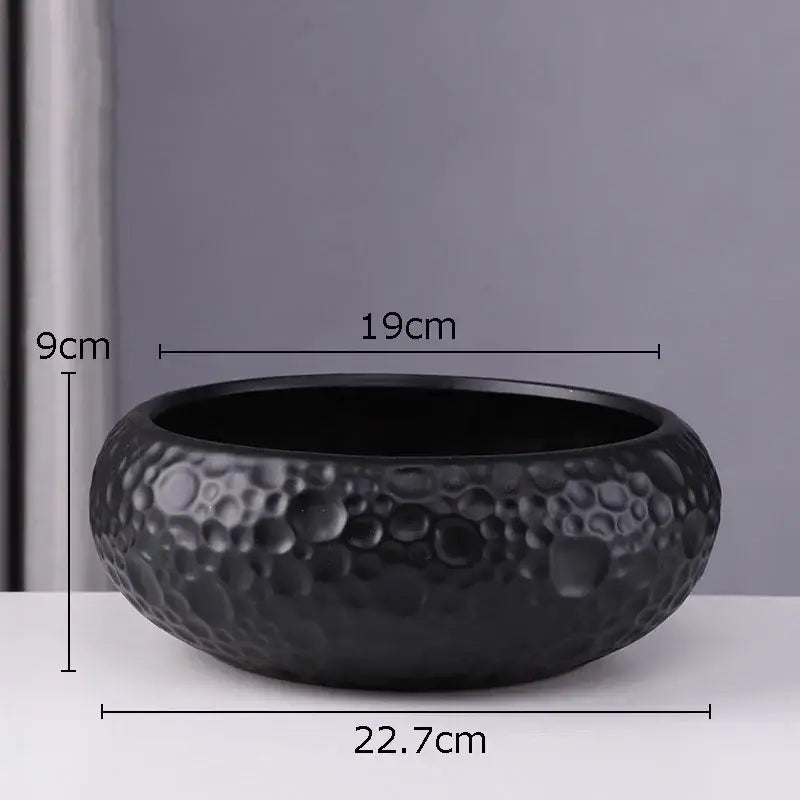 Black ceramic vase with textured hammered surface and raised circular patterns for minimalist ceramic vase decorbites style