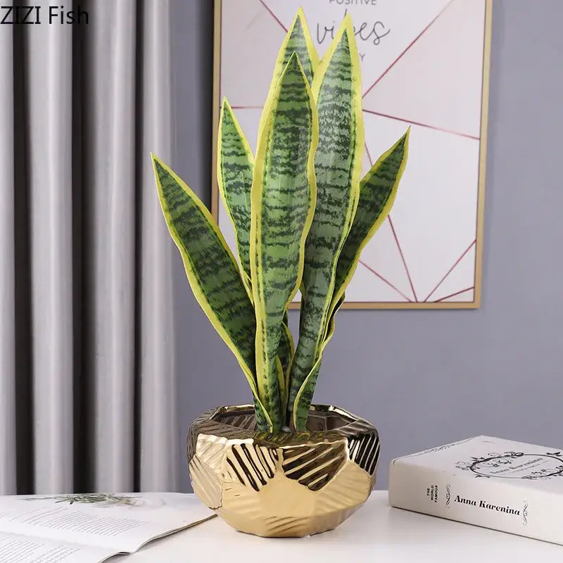 A gold geometric ceramic vase holding a green and yellow-striped snake plant for minimalist decorbites ceramic vase decor