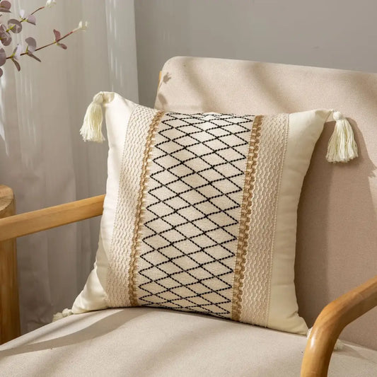 Cream-colored cushion cover with black diamond embroidery and beige trim featuring decorbites geometric tassel accents