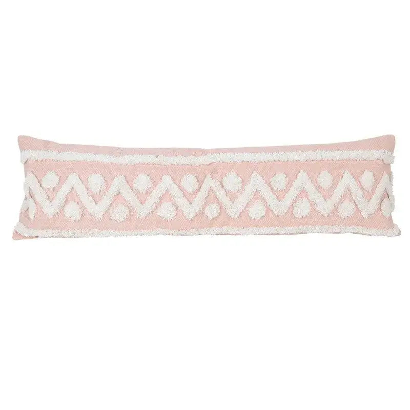 Soft pink geometric tassel tufted pillow cover with white zigzag pattern and pom-pom accents for living room decor