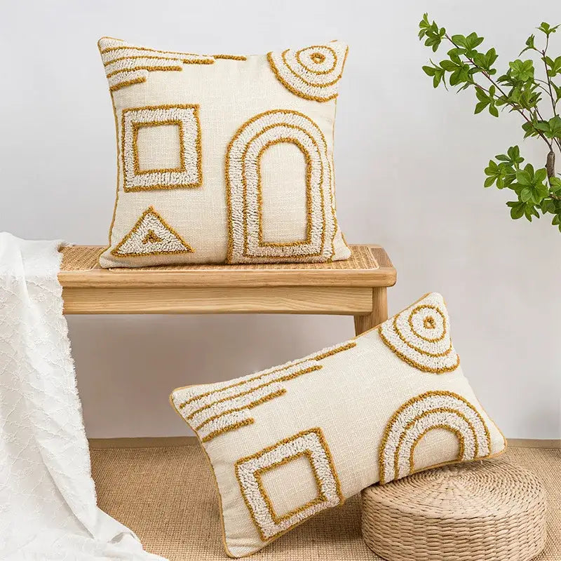 Cream-colored pillow covers with textured gold geometric tufted embroidery for living room decor by decorbites