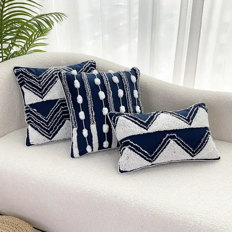 Three navy blue and white geometric tufted cushion covers with textured fabric and pom-pom tassel decorbites decor