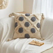 Beige geometric tufted tassel cushion cover with gray pom-pom accents and tassels for living room decor