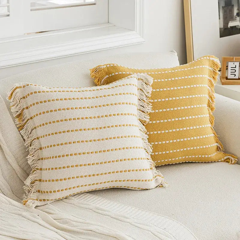 Two rectangular throw pillows with crochet tassels featuring cream and mustard yellow cushion covers by decorbites geometric tufted