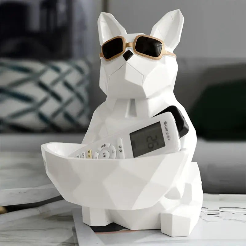 White geometric french bulldog tissue box holder with gold-rimmed sunglasses and remote control in bowl-shaped belly