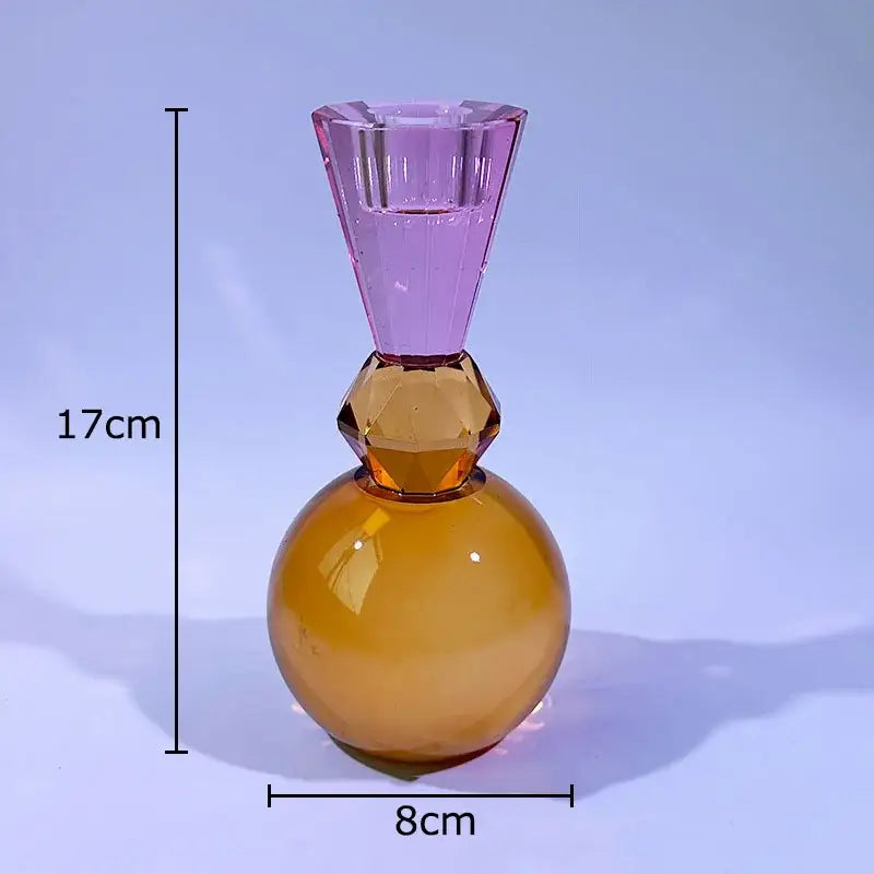 A translucent faceted glass crystal candle holder with an amber rounded base and tapered purple neck for dining room use
