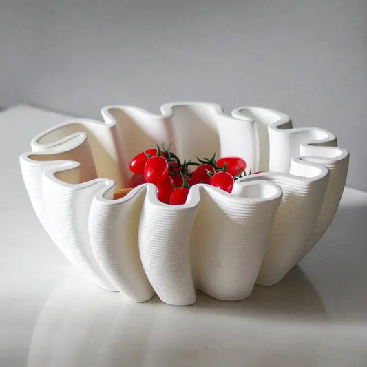 White ceramic fruit plate tray with geometric wavy ribbed design holding red cherry tomatoes for kitchen storage