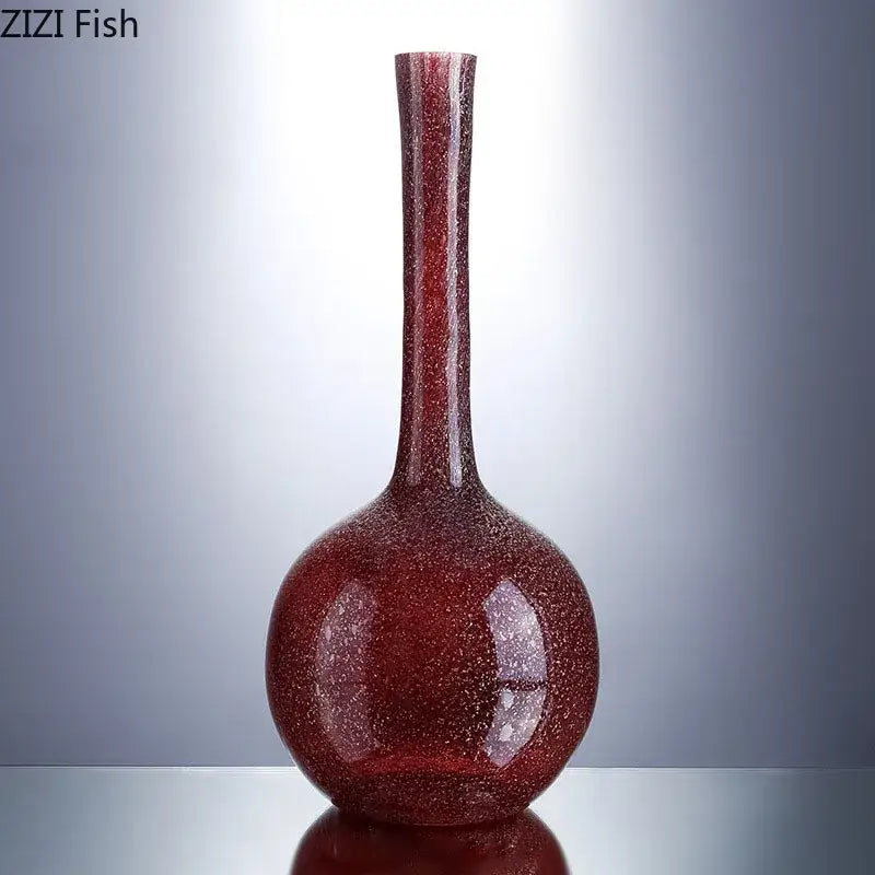 A gilded red glass vase with speckled texture and rounded base holding artificial flowers for decorbites gilded red desk decor