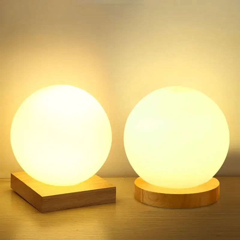 Two warm white glowing glass ball led table lamps with frosted glass orbs on wooden bases for bedroom night light decorbites glass ball