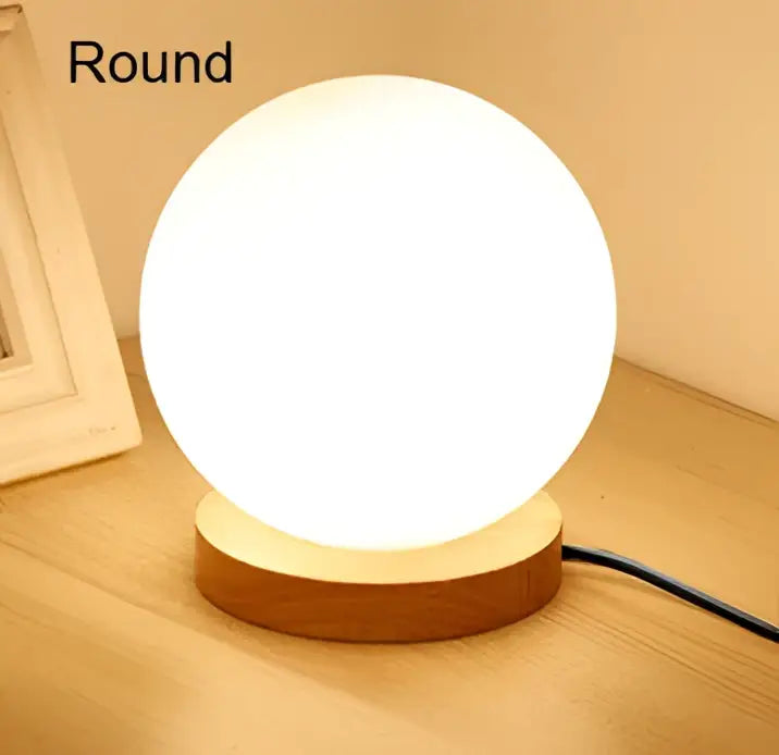 Glass ball led table lamp with softly glowing white spherical glass ball and natural wood base for bedroom night light decorbites glass ball