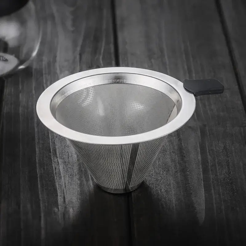 A sleek conical stainless steel filter with black handle for use in a glass coffee pot pour over kitchen carafe