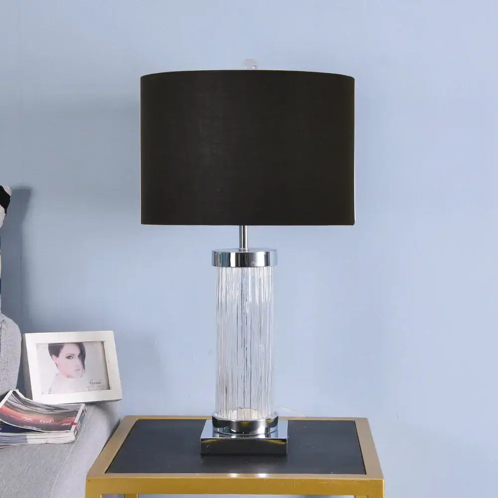 Black drum shade table lamp with clear vertically ribbed glass crystal cylinder body and chrome metal accents for bedroom