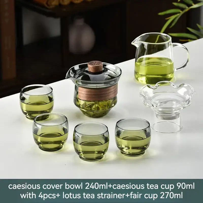 Clear glass gaiwan cup set with wooden lid and copper band includes green cups pitcher and lotus tea filter for dining room