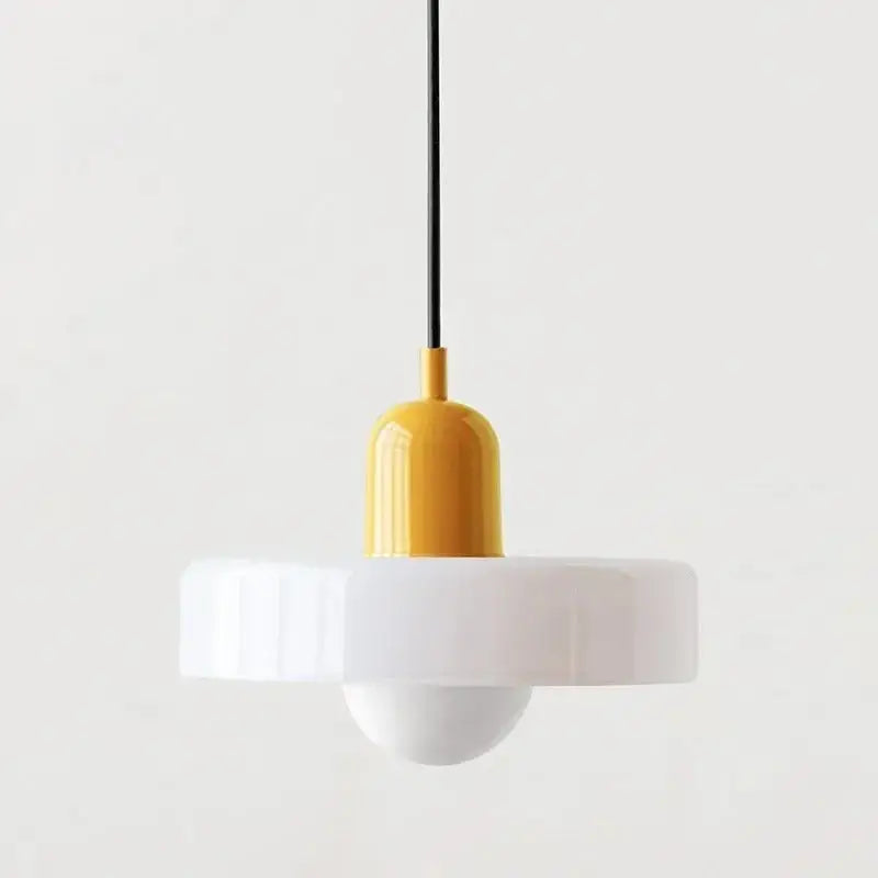 A modern glass pendant lighting with a glossy yellow cylindrical top and white fluted circular shade in Bauhaus style