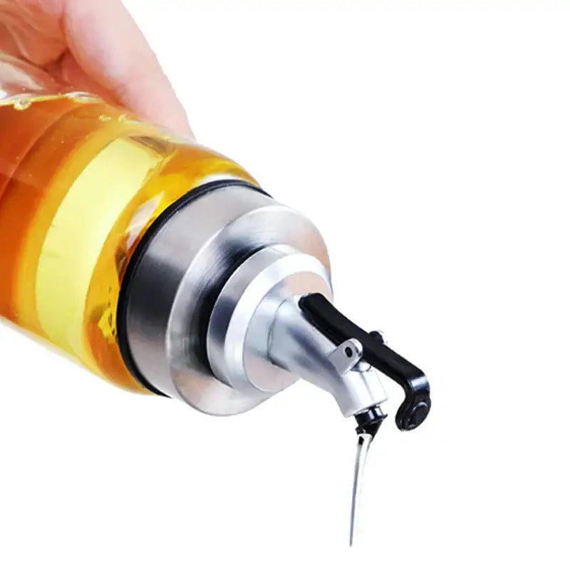 A sleek transparent glass seasoning dispenser bottle with stainless steel spout and black lever for kitchen storage