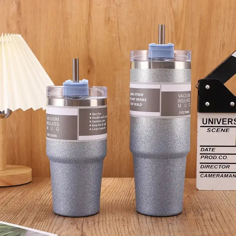 Two silver glitter finish double wall insulated stainless steel mugs with blue straw lids and stainless steel straws