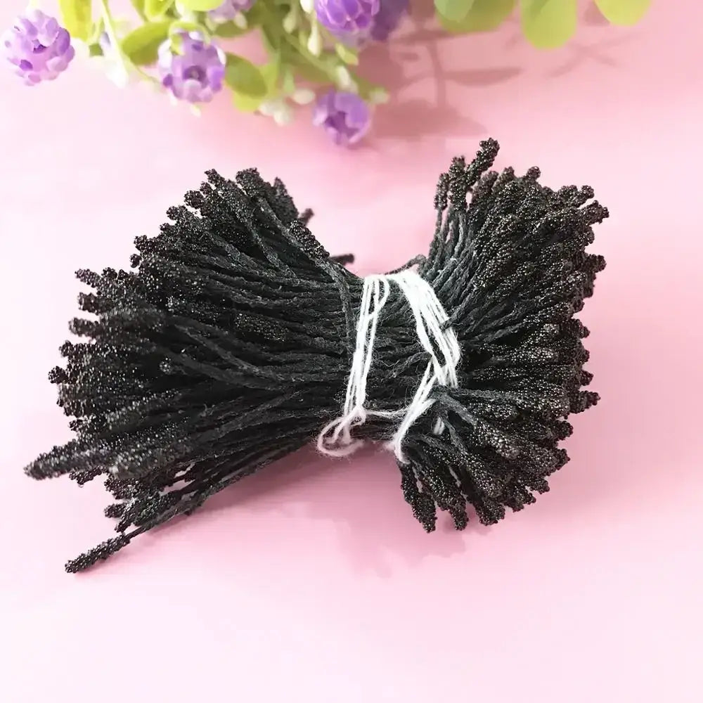 A bundle of black glittery artificial mini flower stamens tied with white string for kids bedroom hair ties