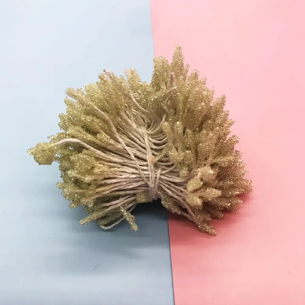 A bundle of golden glittery decorative twine tied with natural string for mini flower stamen hair ties