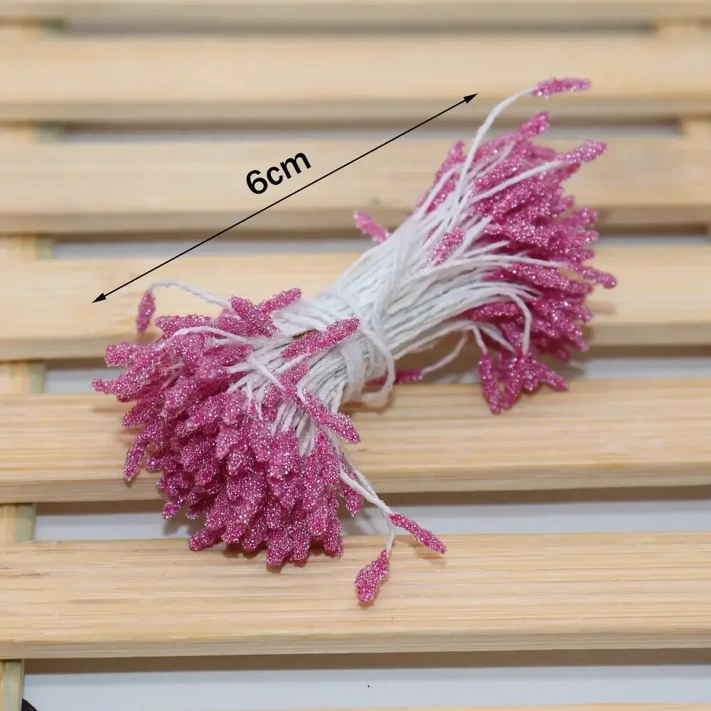 A bundle of 6cm pink glittery mini flower stamen wires tied with white string for kids bedroom hair ties
