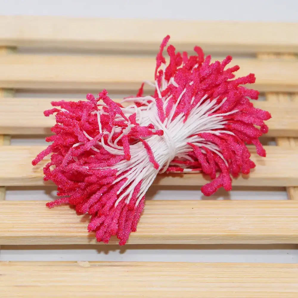 A bundle of vibrant pink and white glittery mini flower stamen floral stems for crafting or kids bedroom decor