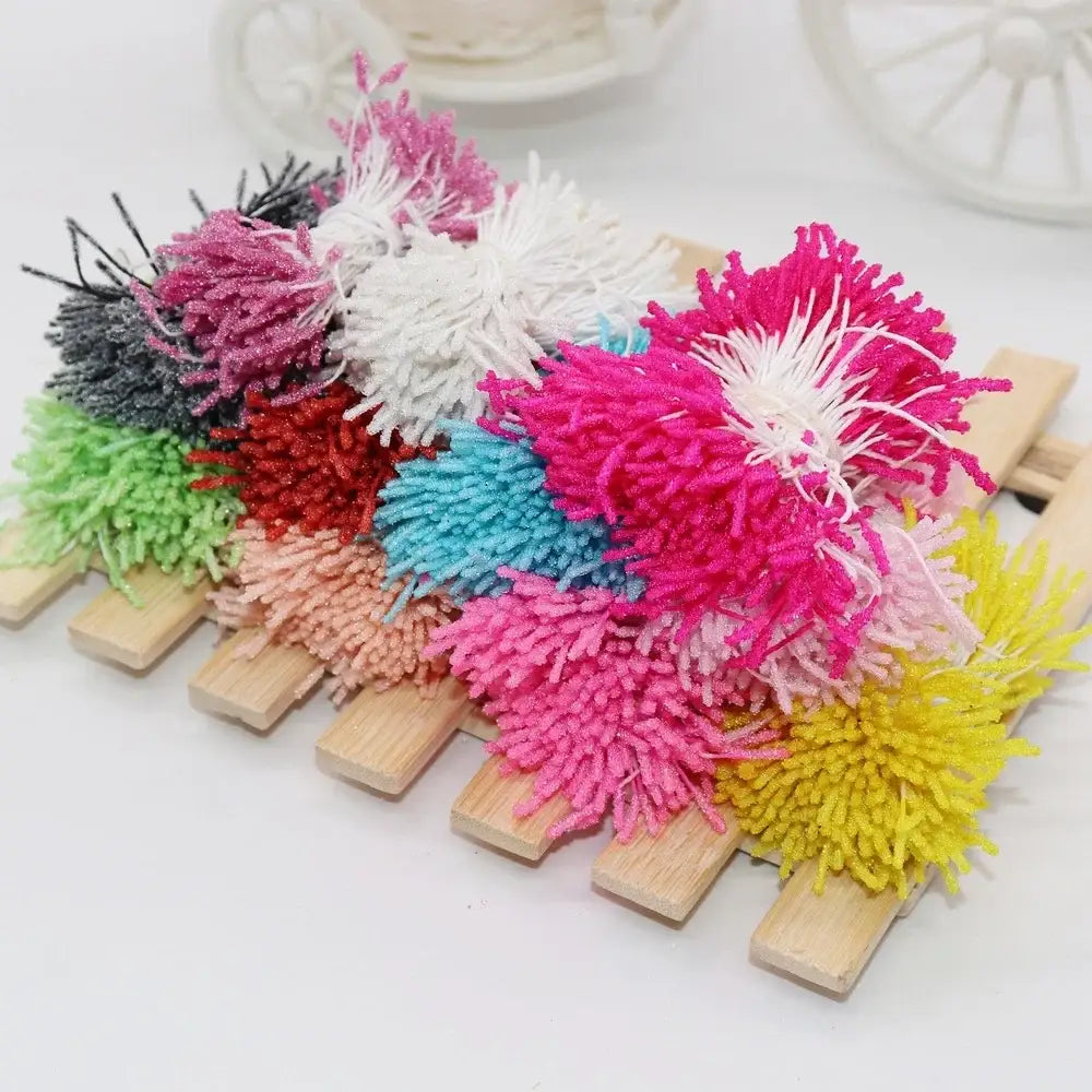 A collection of colorful glitter pom pom mini flower stamen hair ties with yarn texture for kids bedroom decor