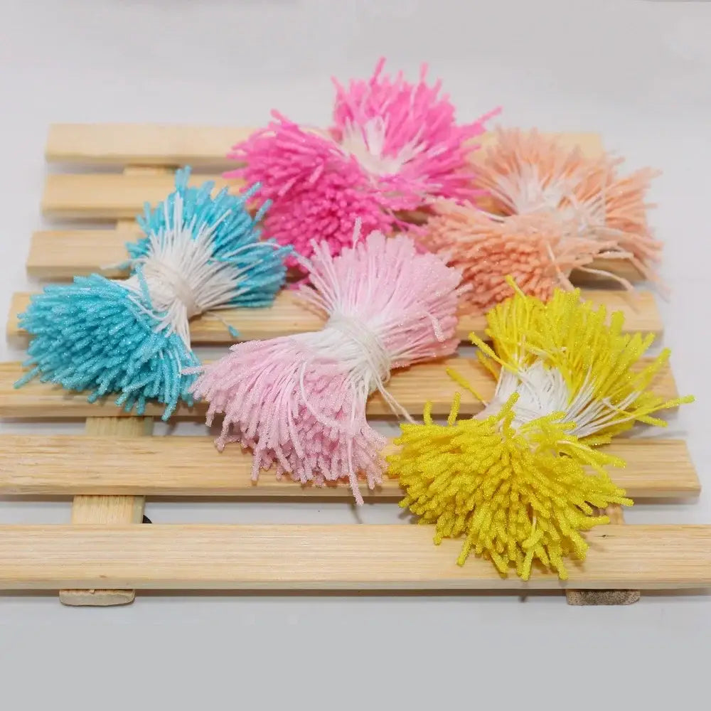 Colorful fluffy pom-pom mini flower stamen hair ties in pink blue yellow and orange with white centers for kids bedroom