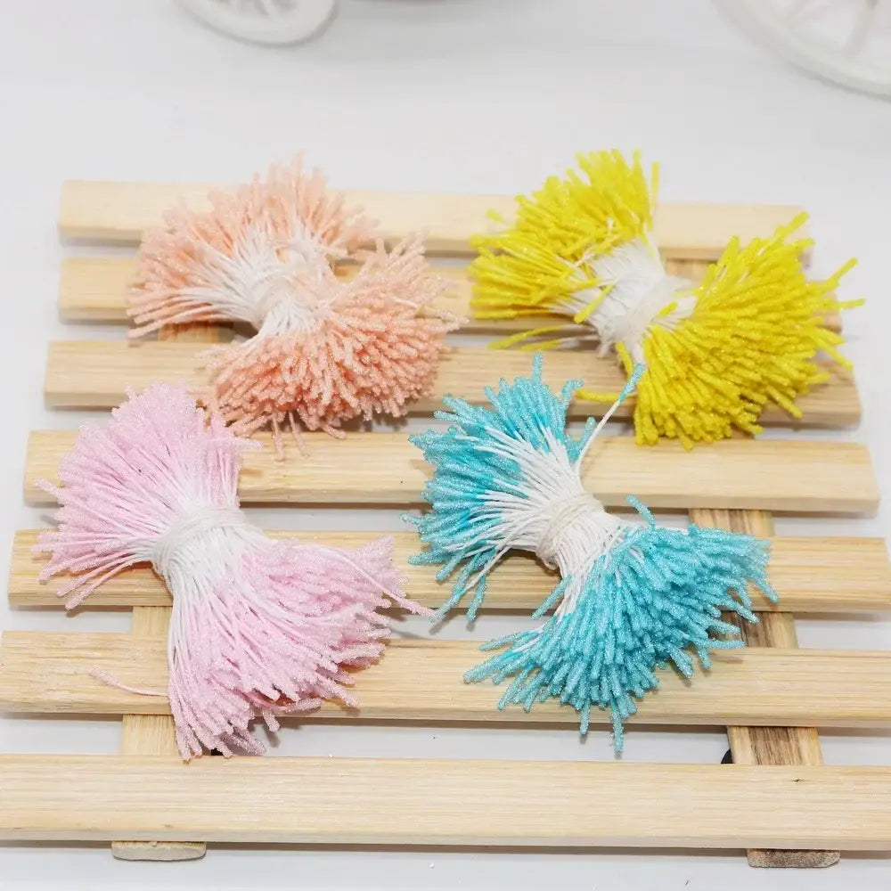 Pastel-colored fluffy tassel mini flower stamen hair ties in peach yellow pink and blue tied with white string for kids bedroom