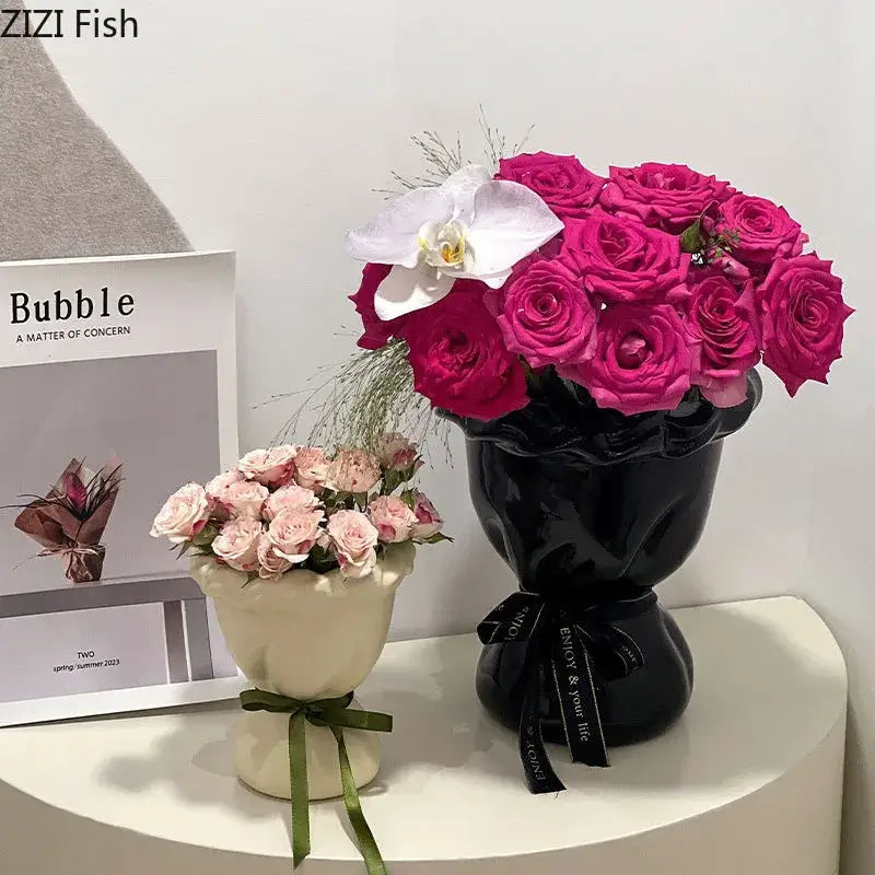 Glossy black ceramic vase shaped like a human head with a black ribbon and pink artificial flowers decorbites ceramic vase