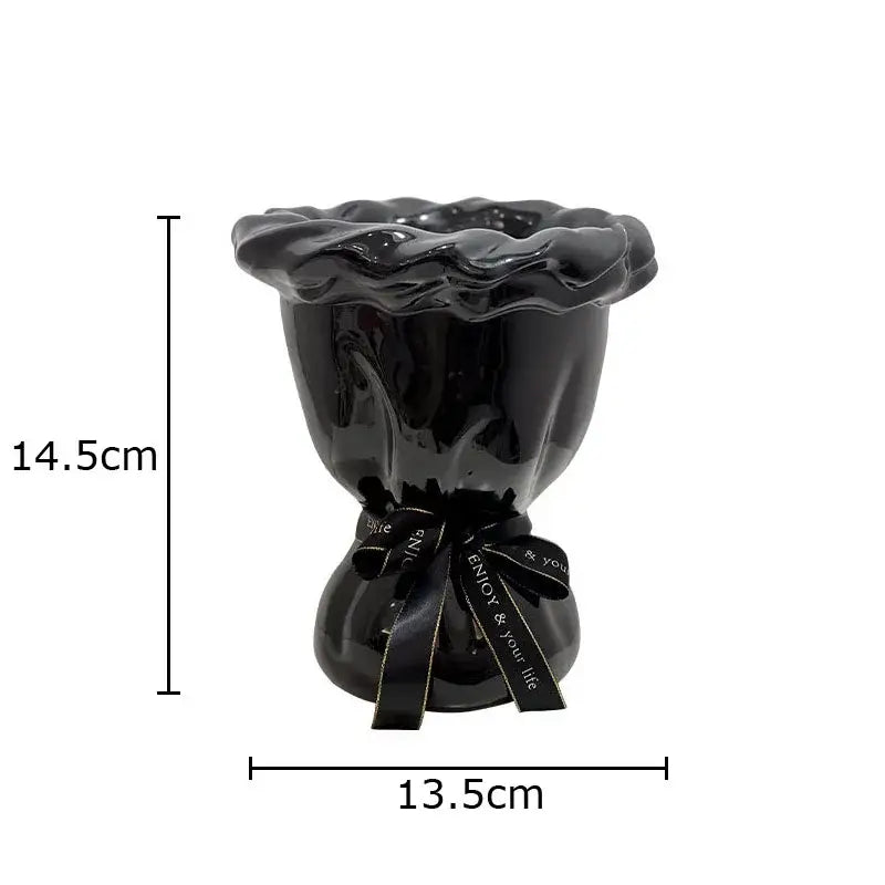 Glossy black ceramic vase with ruffled rim and tied ribbon holding pink artificial flowers for bedroom decorbites decor