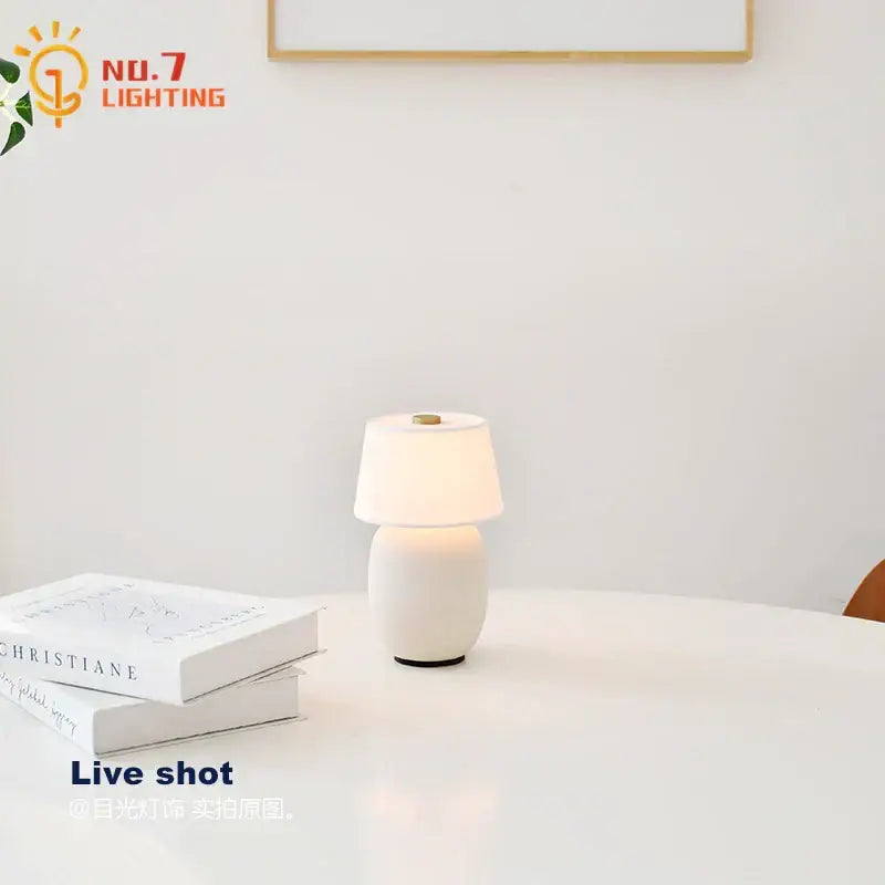 Glossy black ceramics table lamp with white ceramic shade and soft diffused light for bedroom use