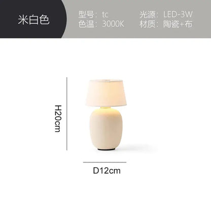 A sleek off-white ceramics table lamp with soft fabric shade and minimalist design for bedroom use