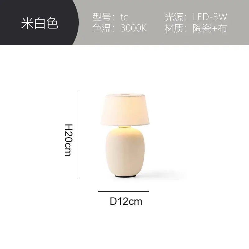 A sleek off-white ceramics table lamp with soft fabric shade and minimalist design for bedroom use