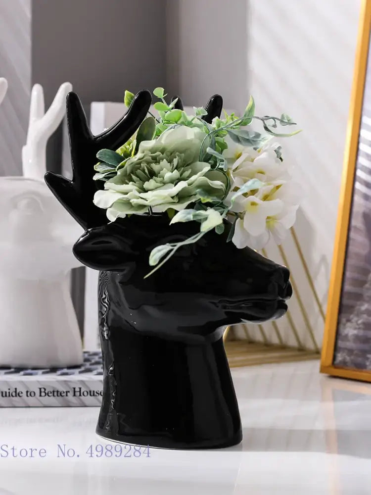 Glossy black deer head ceramic vase holding artificial green and white flowers for living room decorbites decor