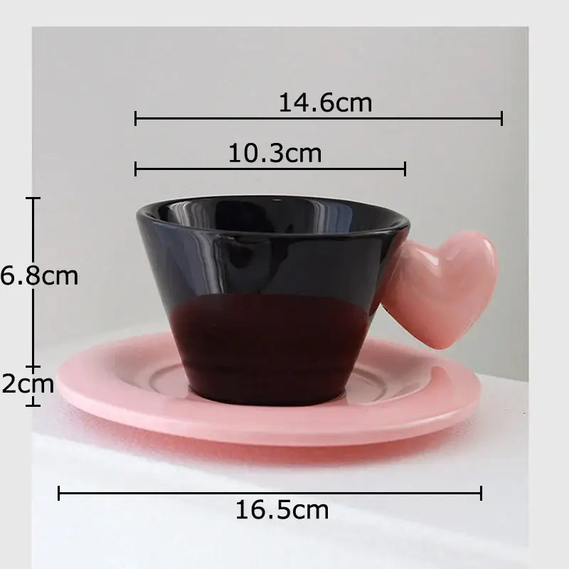 Glossy black porcelain lovers mug set featuring a heart shape pink handle and matching pink saucer for dining room