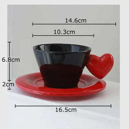 Glossy black porcelain lovers mug with a red heart shape handle on a matching red saucer in lovers mug set
