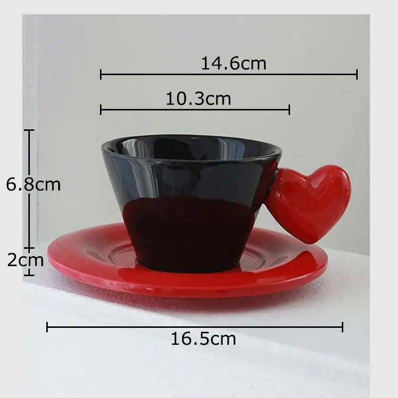 Glossy black porcelain lovers mug with a red heart shape handle on a matching red saucer in lovers mug set