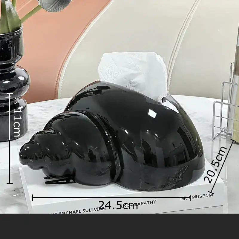 Shiny black ceramic tissue box shaped like a spiral seashell for elegant decorbites conch ceramic use