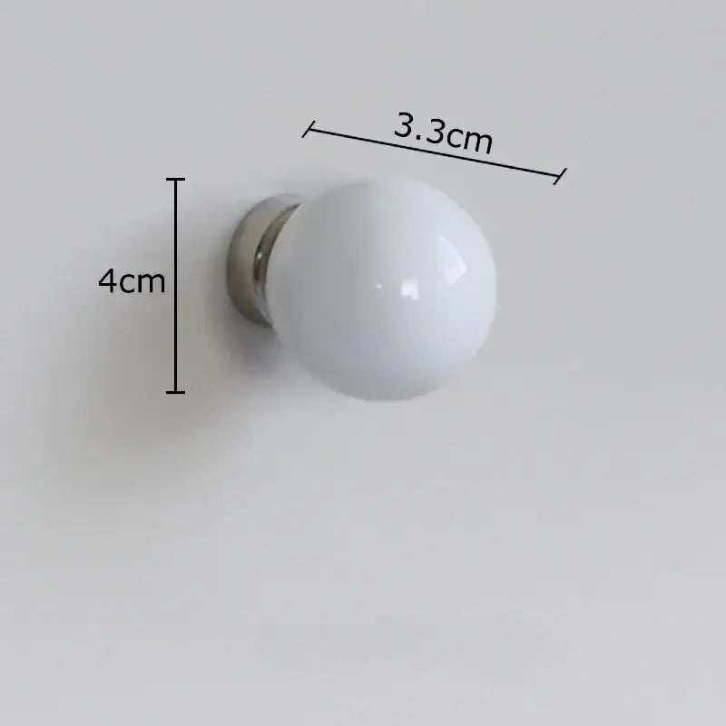 Glossy black and white ceramic wall hook clothing rack with a white spherical wall knob and metallic base for clothing rack use