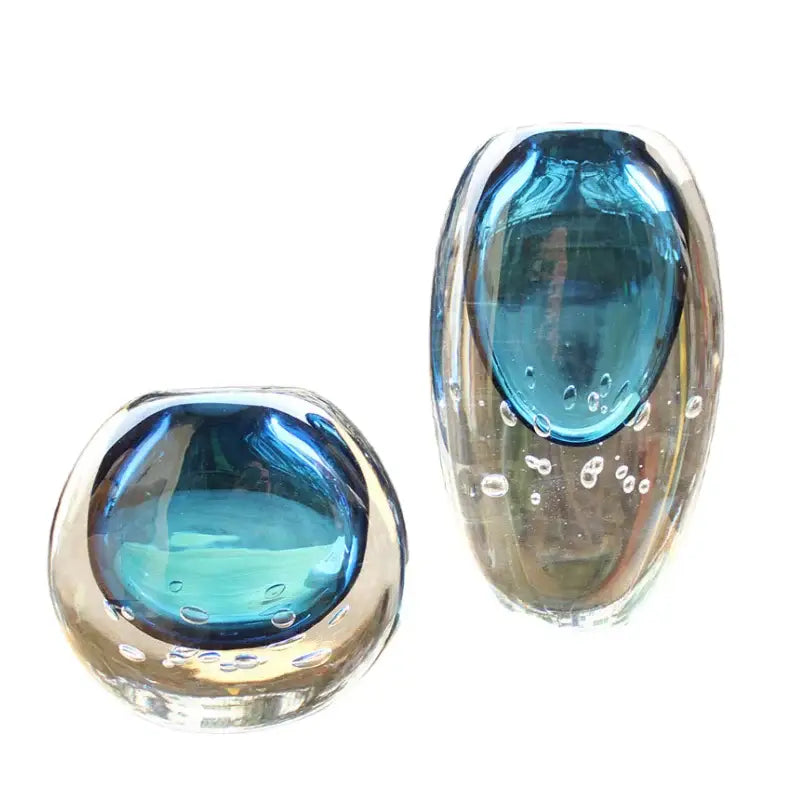 Two translucent decorbites crystal glass paperweights with vibrant blue centers and embedded bubbles for flower pot decor