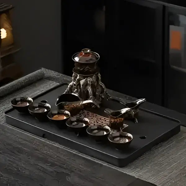Dark bronze ceramic decorbites dragon teapot with intricate motifs on a magnetic rotating tea set tray