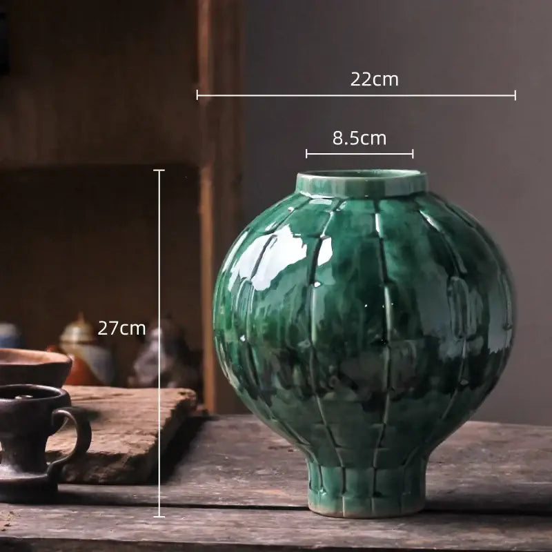 Glossy green ceramic spherical vase with a segmented ribbed design and flared base for living room decor