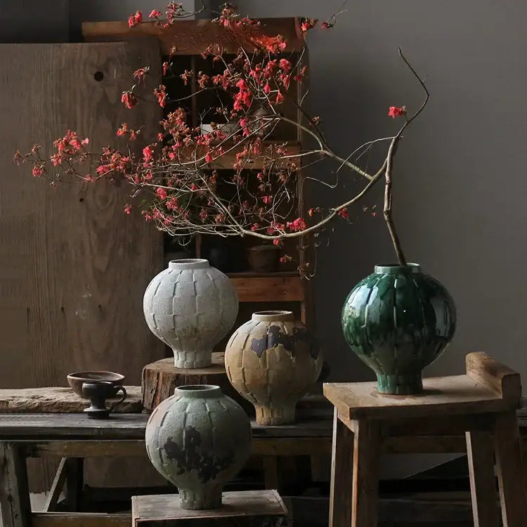 Glossy green ceramic spherical vase with a ribbed segmented design and rounded body for living room decor