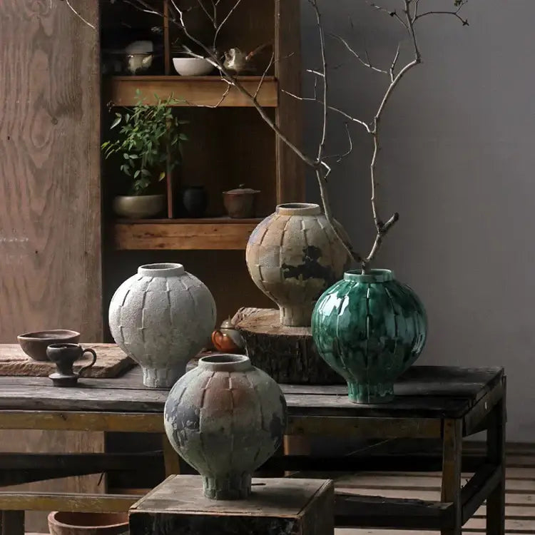 Glossy green ceramic spherical vase with ribbed segmented design and flared opening for living room decor