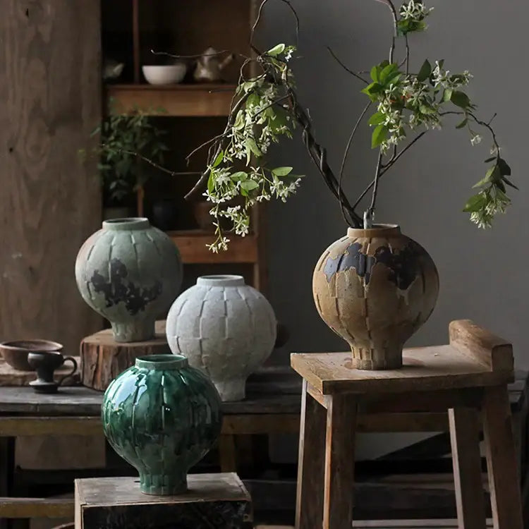 A rustic green ceramic spherical vase with crackle glaze texture perfect for living room ribbed decor
