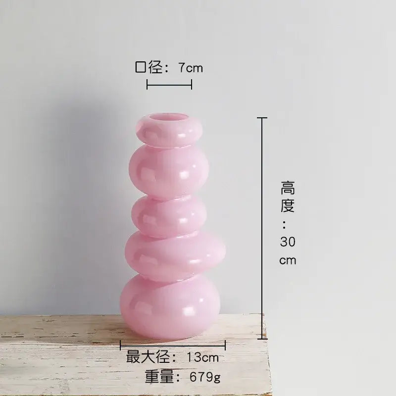 A translucent pink glass vase with a stacked rounded design for pebble stack floral arrangement decor