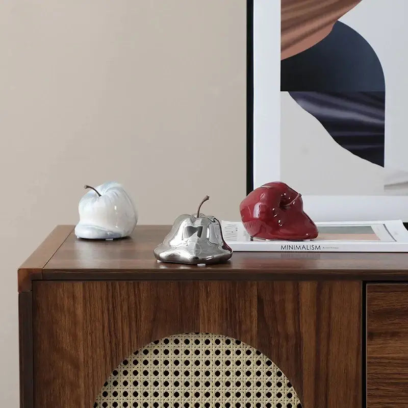 Shiny metallic pear shaped decorative object resembling a glossy red abstract melting apple ceramic sculpture decorbites abstract melting apple for living room decor