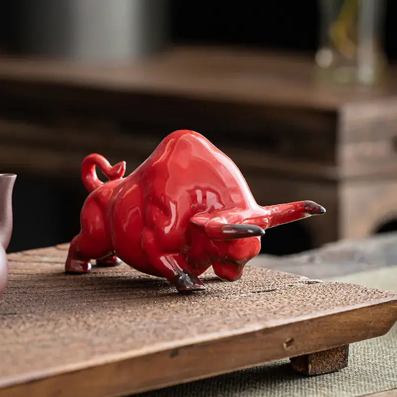 Glossy red ceramic bull figurine with detailed sculpting ideal for office decor by decorbites bull figurine
